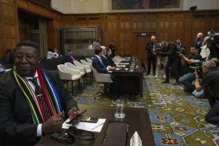 Χθεσινό στιγμιότυπο από το Διεθνές Δικαστήριο της Χάγης. Σε πρώτο πλάνο ο πρέσβης της Νότιας Αφρικής στην Ολλανδία, Β. Μαντονσέλα, και στο βάθος η νομική ομάδα του Ισραήλ που έχει συγκεντρώσει το ενδιαφέρον των φωτογράφων λίγο πριν από την είσοδο των δικαστών στην αίθουσα